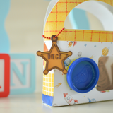 Close-up of a star name keychain on a play dough box
