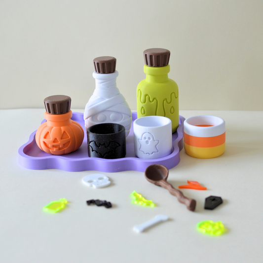 3D printed Halloween potion playset with purple tray, potion bottles, cauldron, cups and acrylic pretend food