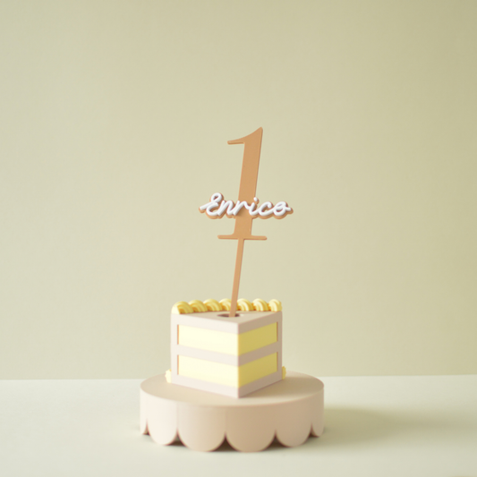 Personalised name and number cake topper on a slice of birthday cake