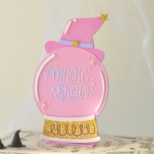 Pink Magic Brews acrylic Halloween sign with holographic gold details and 3D spiders on a freestanding base
