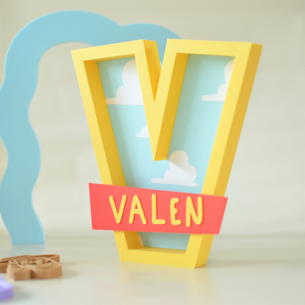 Yellow 3D printed letter V with sky print and personalised name banner