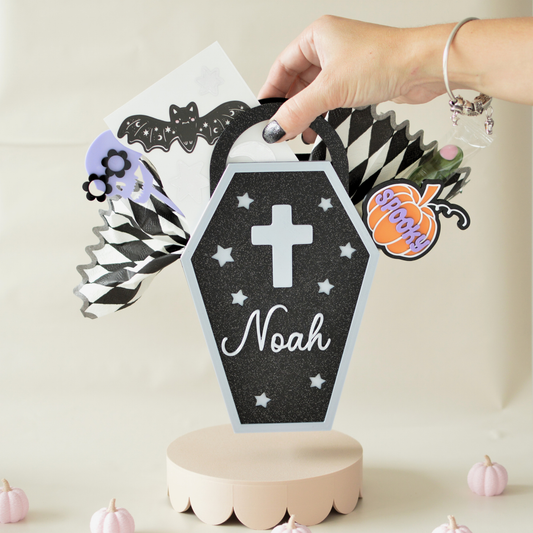 Hand lifting a personalised coffin treat box by its handle