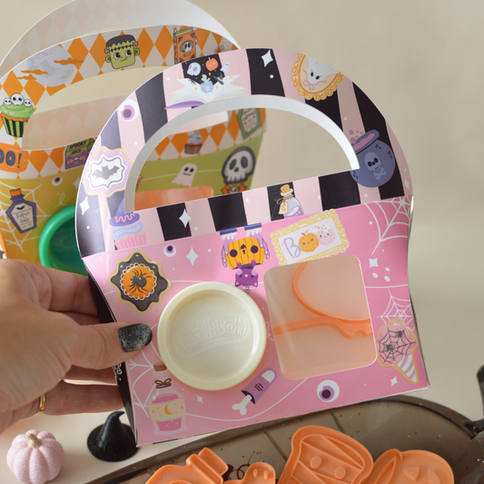 Hand holding a Halloween play dough box with white dough
