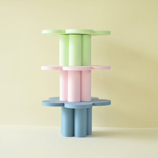 Three flower cake plates stacked in green, pink and blue